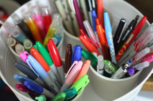 Organized craft cabinet: store pens and markers in white buckets